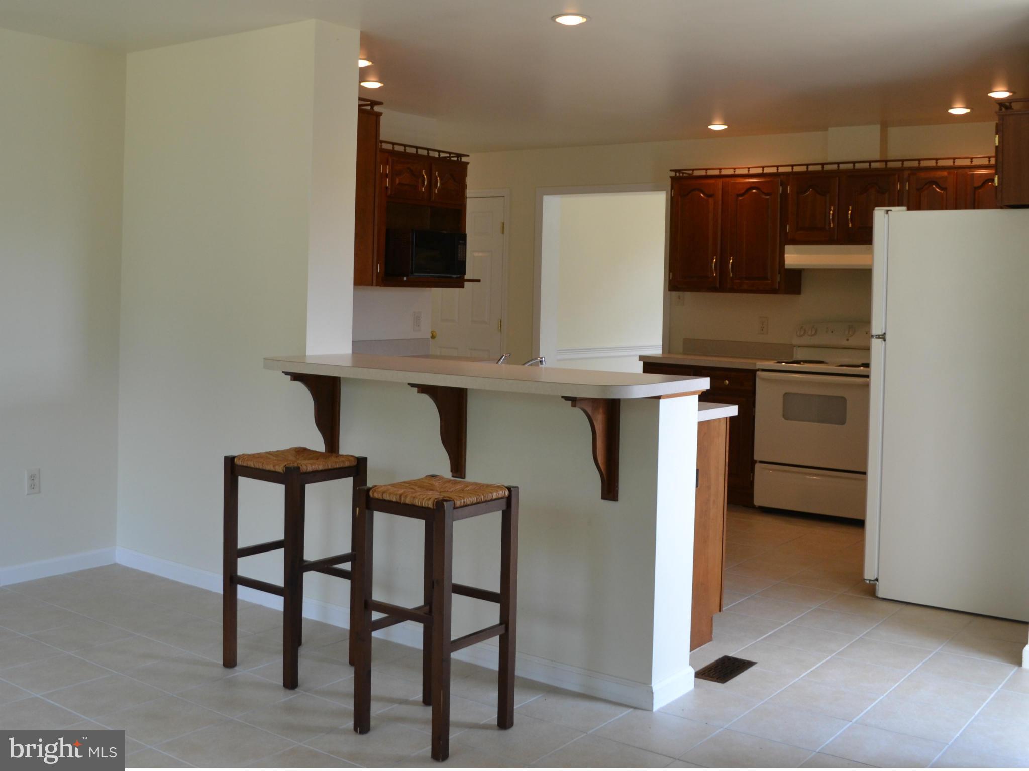 381 Reynolds Road Cross Junction, VA 22625 - Photo 7 of 28 a kitchen with stainless steel appliances kitchen island granite countertop a table chairs microwave and sink