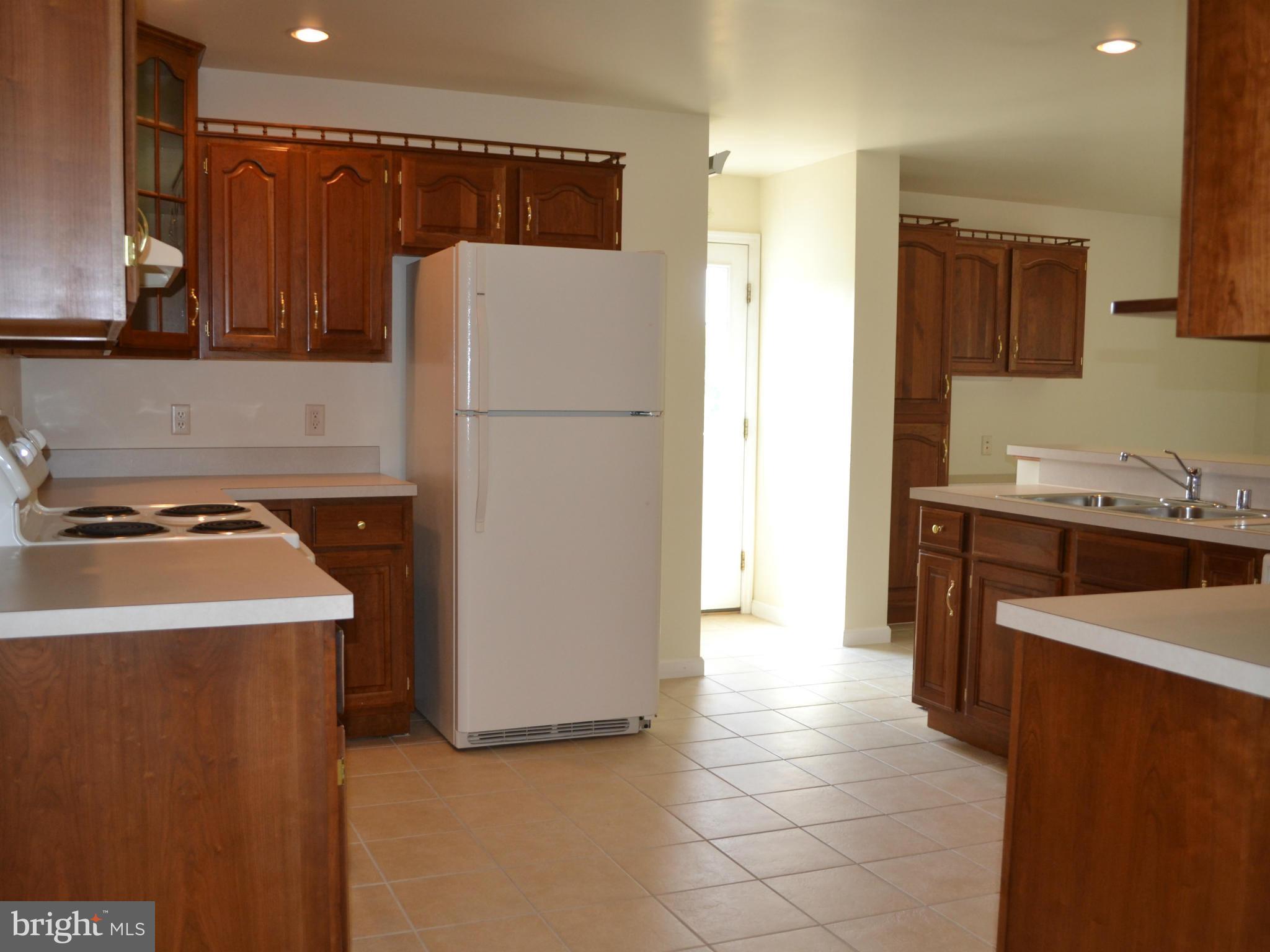 381 Reynolds Road Cross Junction, VA 22625 - Photo 8 of 28 a kitchen with a sink a refrigerator and a stove top oven