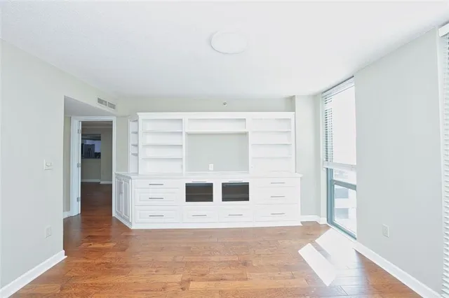 a view of a hallway with wooden floor and a living room