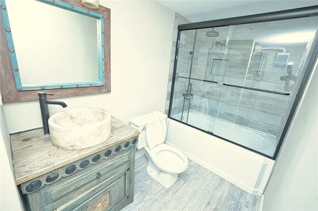 a bathroom with a granite countertop sink mirror vanity and toilet