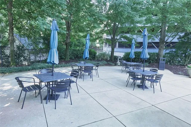 a view of a patio with a table and chairs and a small yard