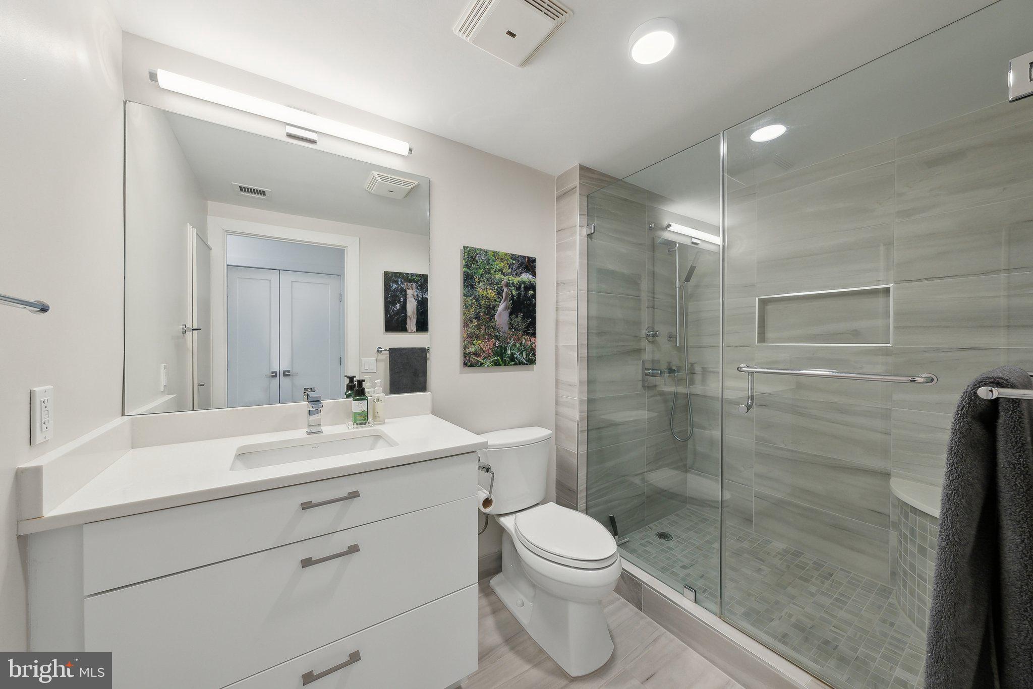 631 D Street Northwest, Unit 241 Washington, DC 20004 - Photo 20 of 81 a bathroom with a toilet a sink a mirror and vanity