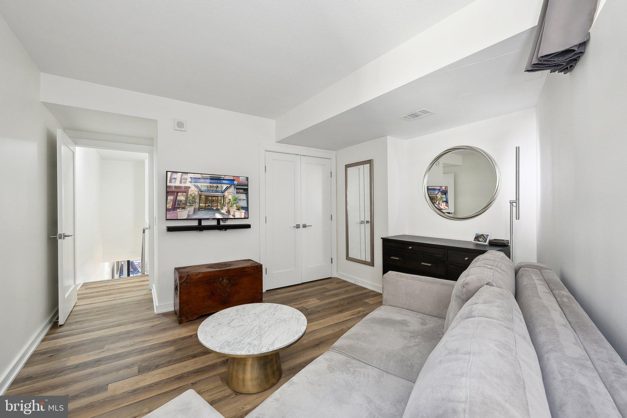 631 D Street Northwest, Unit 241 Washington, DC 20004 - Photo 25 of 81 a living room with furniture a mirror and a wooden floor