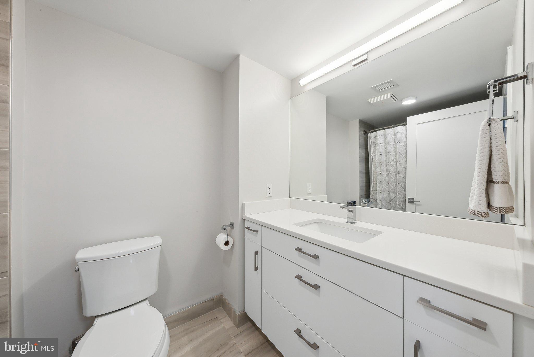 631 D Street Northwest, Unit 241 Washington, DC 20004 - Photo 29 of 81 a bathroom with a toilet sink and mirror