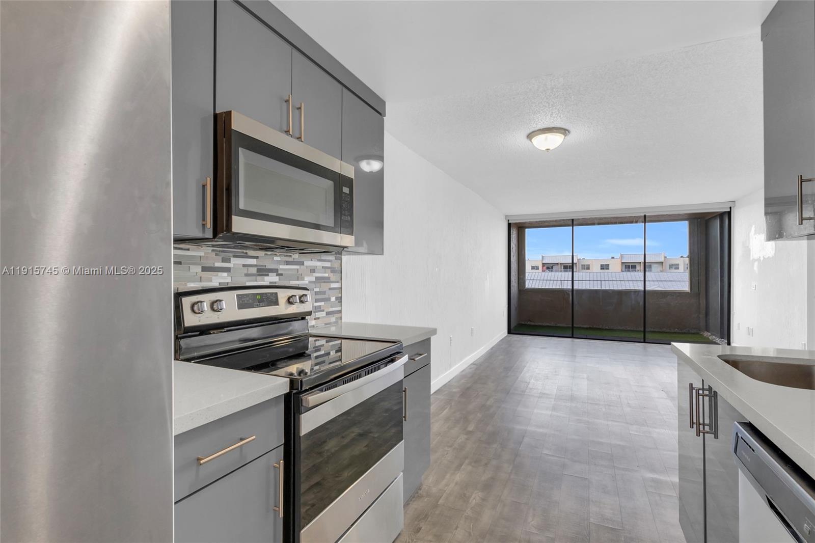 10400 Southwest 108th Avenue, Unit A413 Miami, FL 33176 - Photo 5 of 25 a kitchen with granite countertop a stove and a microwave