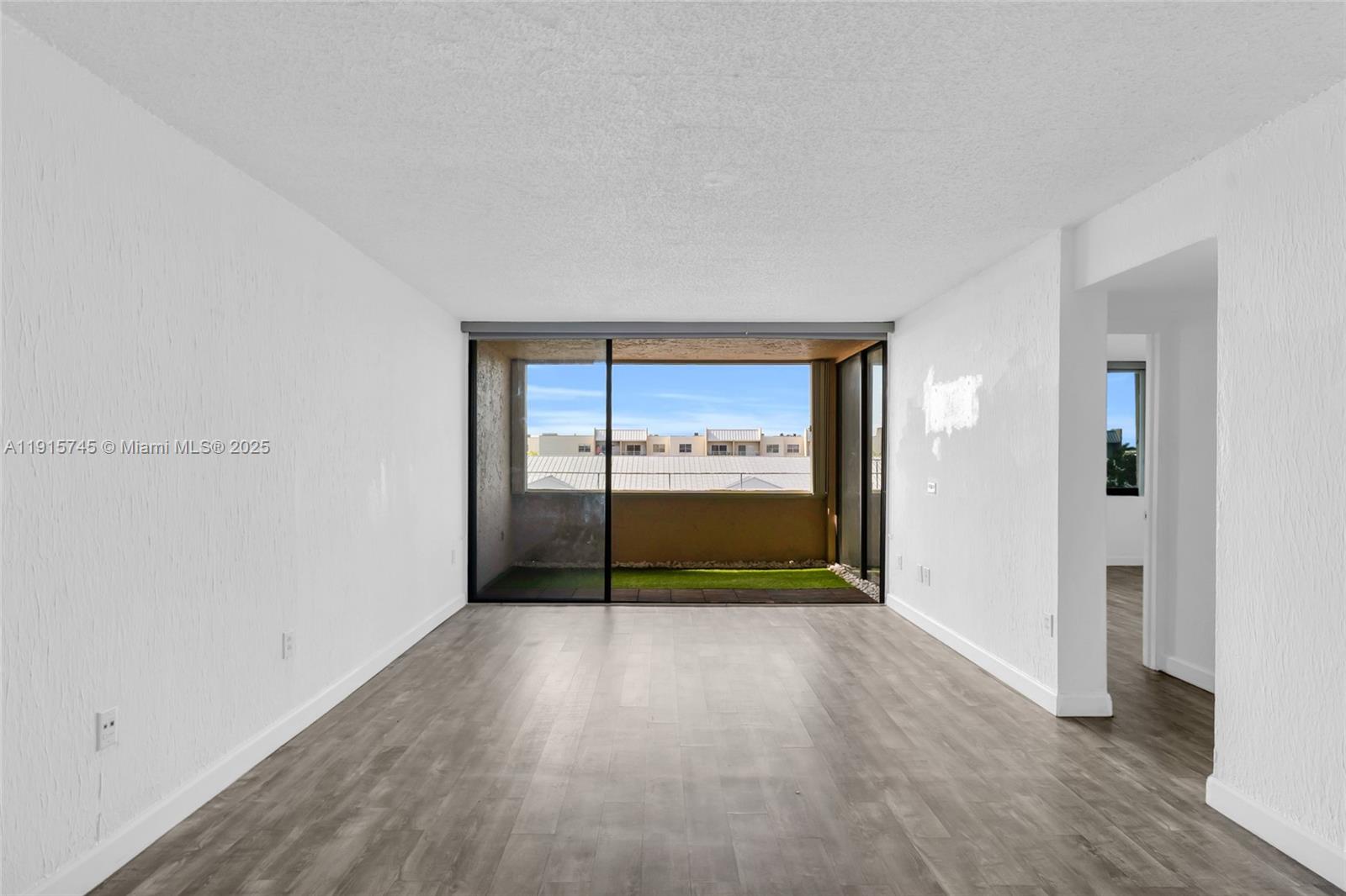 10400 Southwest 108th Avenue, Unit A413 Miami, FL 33176 - Photo 8 of 25 a view of an empty room with wooden floor and a window