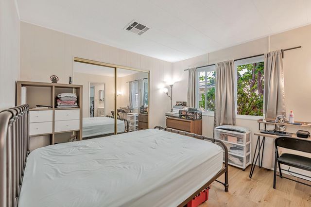 a large bedroom with a bed and large windows