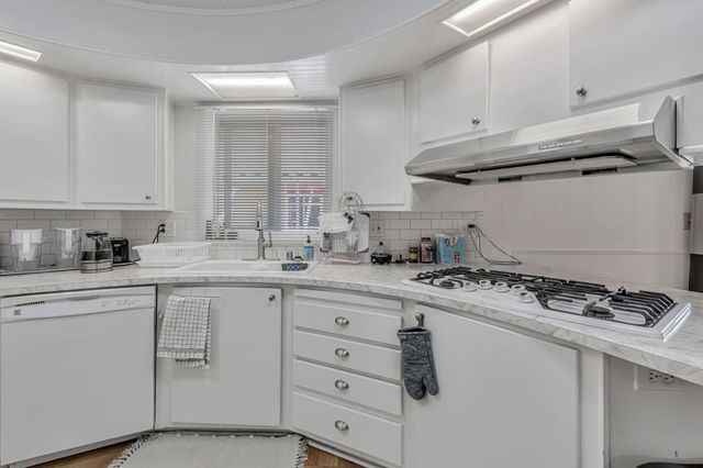 a kitchen with white cabinets and appliances