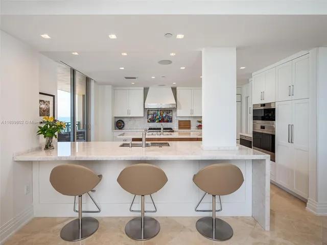 a kitchen with stainless steel appliances granite countertop a kitchen island a stove a cabinets and chairs