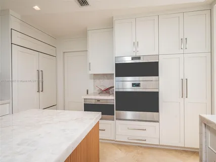 a kitchen with stainless steel appliances granite countertop a refrigerator and a stove