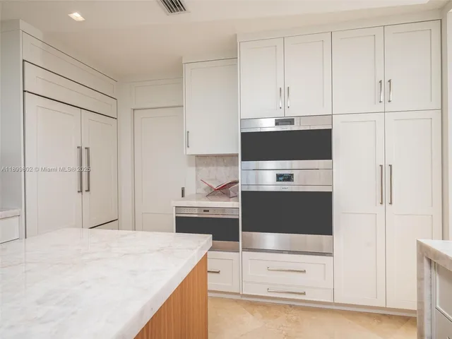 a kitchen with stainless steel appliances granite countertop a refrigerator and a stove
