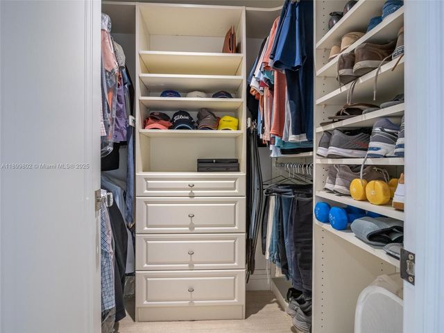 a view of walk in closet with clothes and shoes
