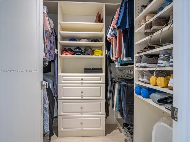 a view of walk in closet with clothes and shoes