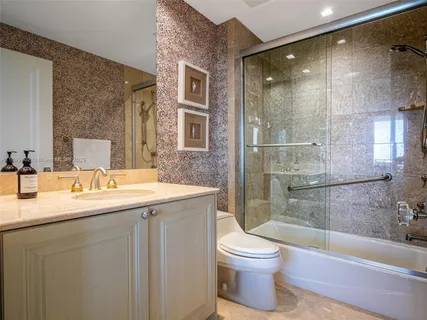 a bathroom with a granite countertop sink toilet and shower