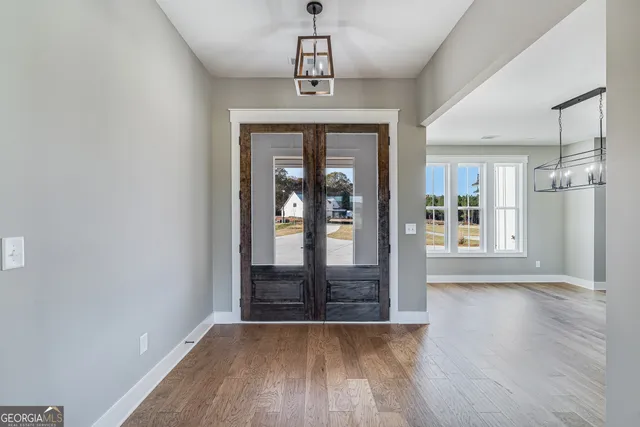 a view of a hallway with wooden floor and a chandelier