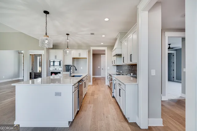 a large kitchen with stainless steel appliances lots of counter space and wooden floor