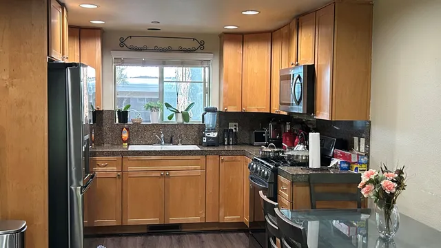 a kitchen with stainless steel appliances granite countertop a refrigerator and a sink