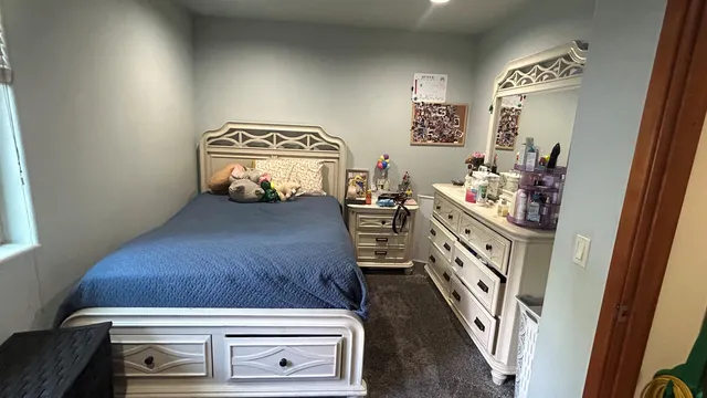 a view of bedroom with furniture and mirror