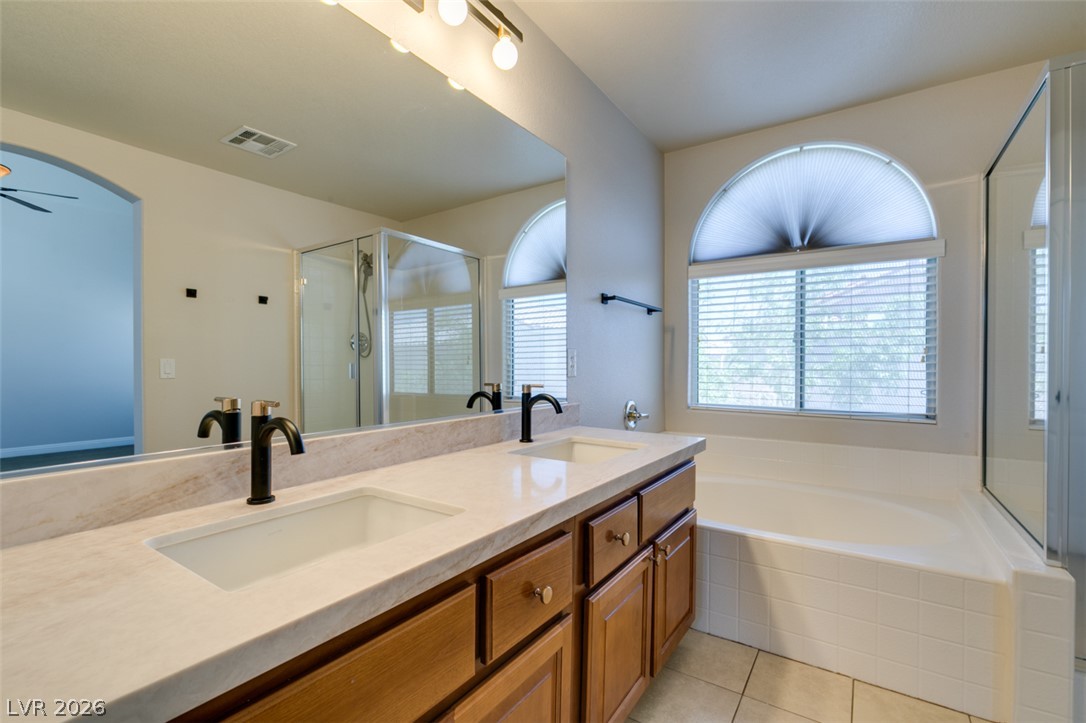 8909 Houston Ridge Avenue Las Vegas, NV 89178 - Photo 37 of 45 Dual vanities and a deep soaking tub create a luxurious primary bathroom retreat.