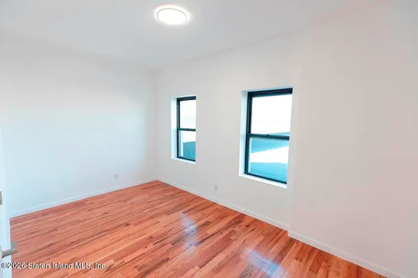 a view of empty room with wooden floor