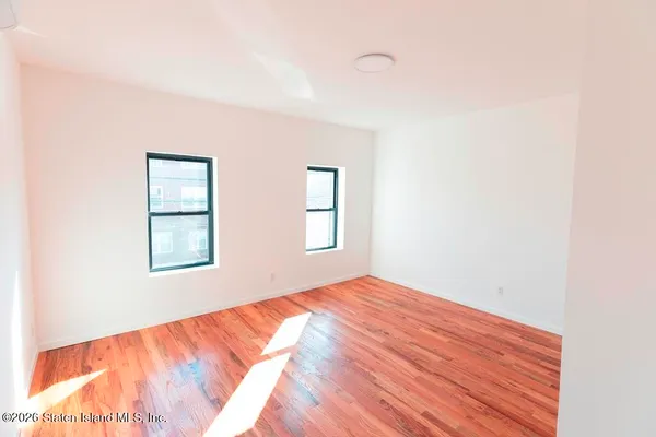 a view of empty room with wooden floor