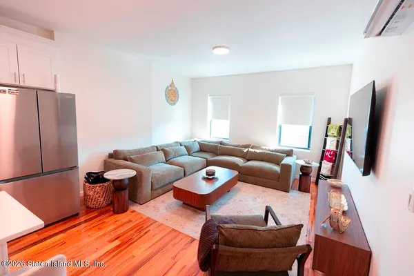 a kitchen with a refrigerator a stove top oven a sink dishwasher and white cabinets with wooden floor