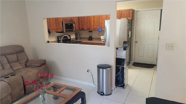 a kitchen with granite countertop a refrigerator and a stove top oven