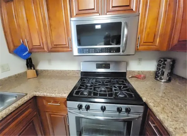 a kitchen with stainless steel appliances granite countertop a refrigerator stove top oven a sink and dishwasher