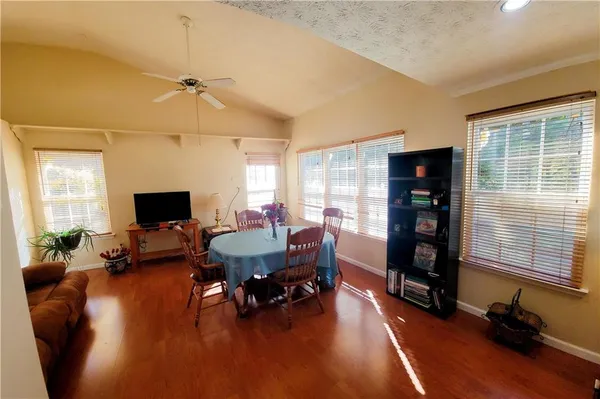 a living room with furniture and a flat screen tv with wooden floor
