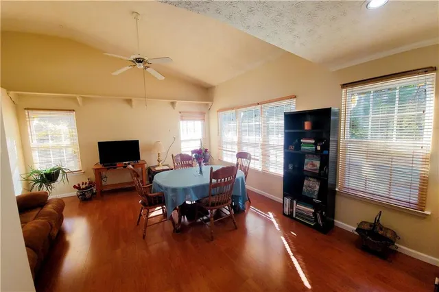 a living room with furniture and a flat screen tv with wooden floor