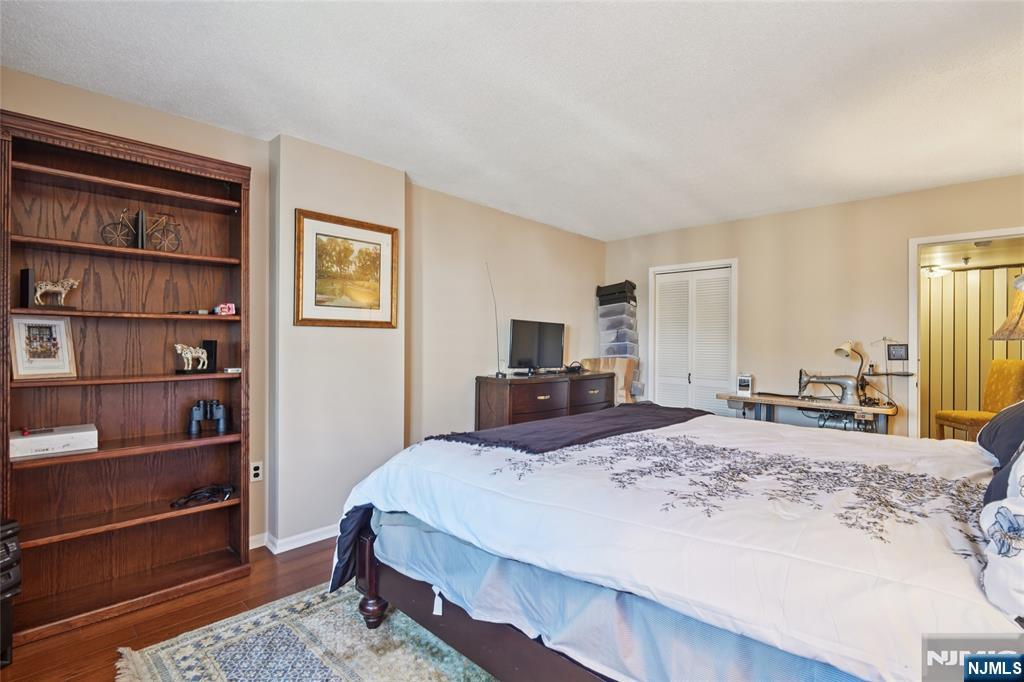 245 Prospect Avenue, Unit 5B Hackensack, NJ 07601 - Photo 15 of 35 a bedroom with a bed a dresser and book shelf