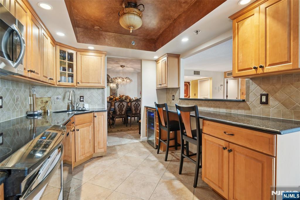 245 Prospect Avenue, Unit 5B Hackensack, NJ 07601 - Photo 8 of 35 a kitchen with stainless steel appliances granite countertop a sink and cabinets