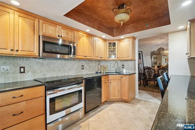 a kitchen with stainless steel appliances granite countertop a stove sink microwave and cabinets