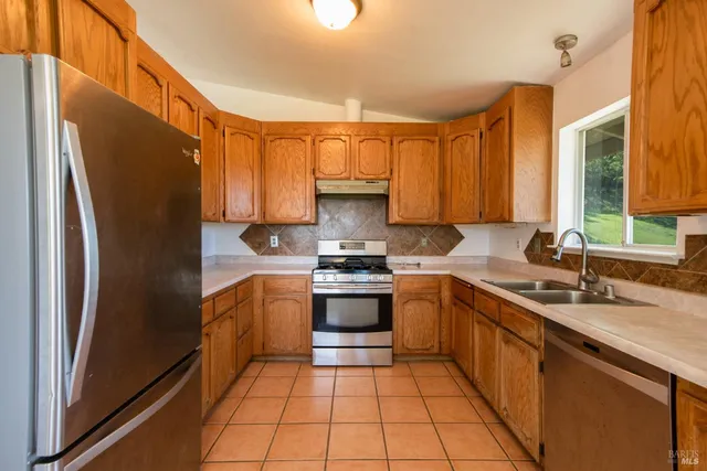 a kitchen with stainless steel appliances granite countertop a refrigerator and a sink