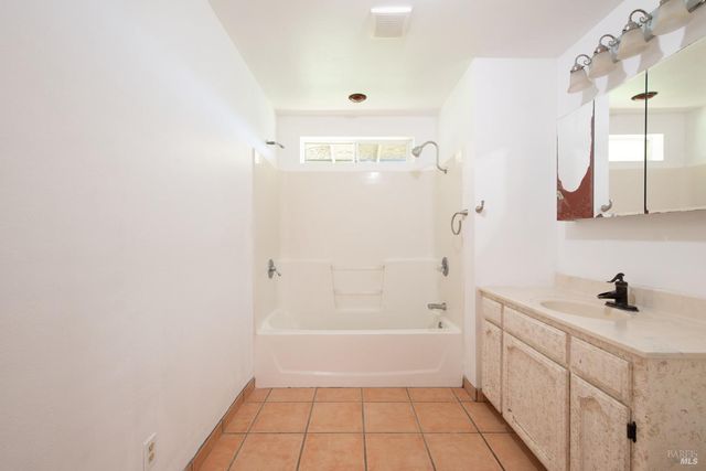 a bathroom with a shower a sink and a mirror