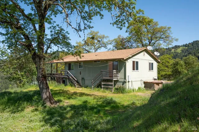 a view of backyard with wooden fence and a bench
