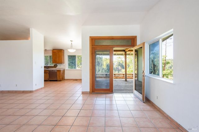 a view of a kitchen with kitchen island granite countertop a refrigerator and a sink