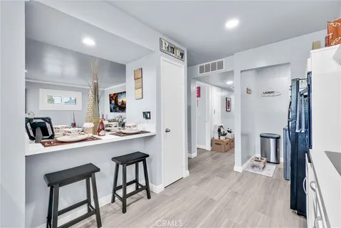 a large white kitchen with stainless steel appliances lots of white cabinets and chandelier