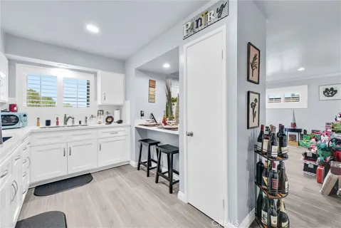 a kitchen with white cabinets and refrigerator