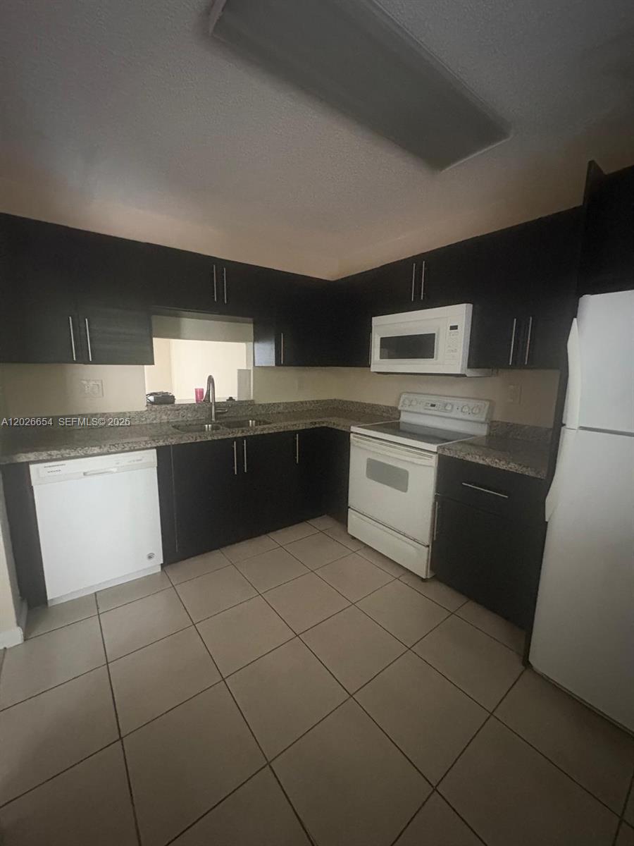 4174 Inverrary Drive, Unit 903 Lauderhill, FL 33319 - Photo 36 of 36 a kitchen with stainless steel appliances granite countertop a sink and a stove