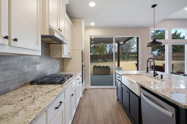 a kitchen with stainless steel appliances granite countertop a sink stove and cabinets