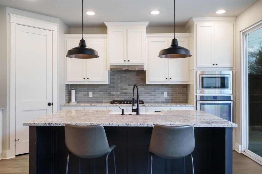 313 East 3rd Street Prosper, TX 75078 - Photo 13 of 38 a kitchen with stainless steel appliances granite countertop a sink a stove and a refrigerator