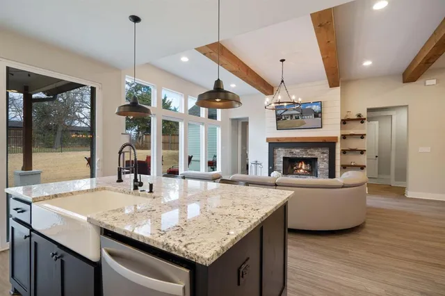 a kitchen with a counter space a sink and living room view