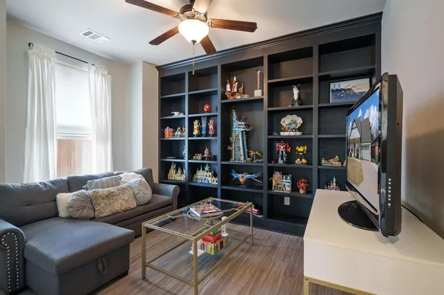 a living room with furniture and a book shelf