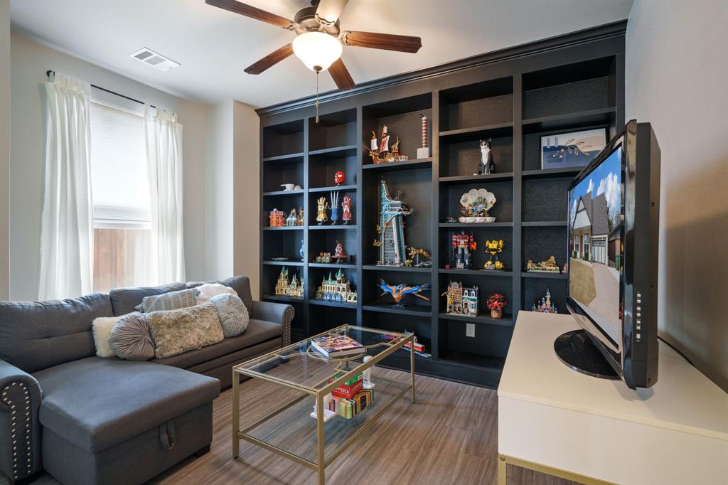 313 East 3rd Street Prosper, TX 75078 - Photo 27 of 38 a living room with furniture and a book shelf