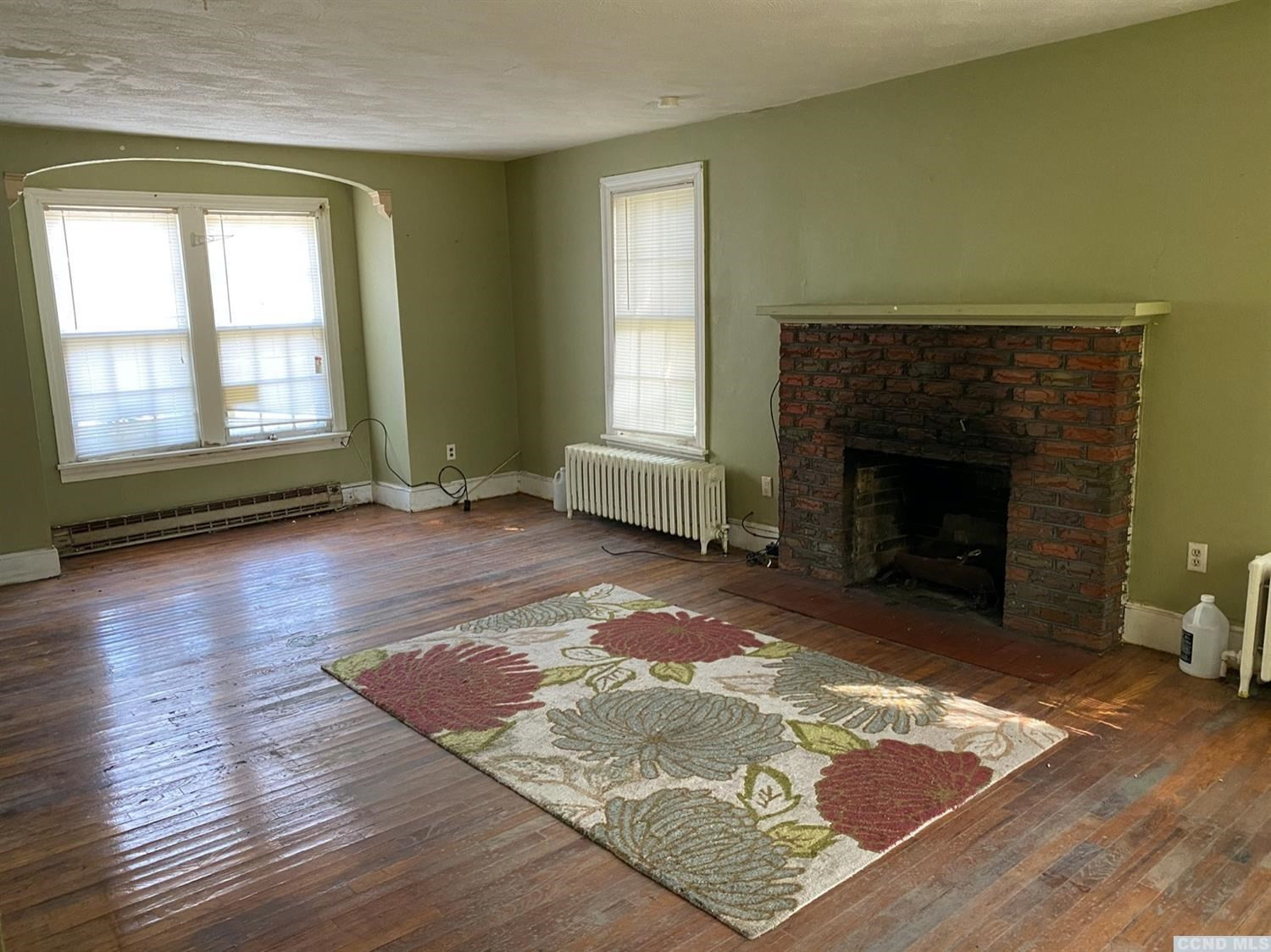 413 Stone Mill Road Claverack, NY 12534 - Photo 8 of 18 a living room with hard wood floors and a fireplace