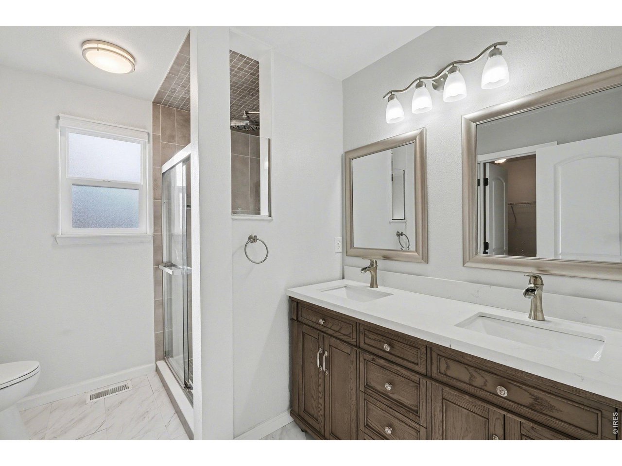 7347 Atlantis Street Wellington, CO 80549 - Photo 9 of 23 Primary bathroom with dual sinks and a walk-in shower