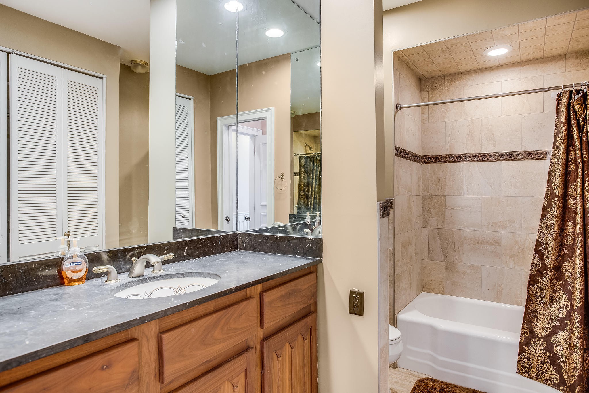 601 Self Hollow Road Rockford, TN 37853 - Photo 16 of 40 a bathroom with a granite countertop sink a mirror a shower and a bathtub