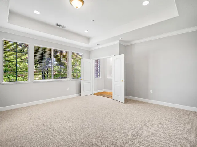 an empty room with a fireplace and windows