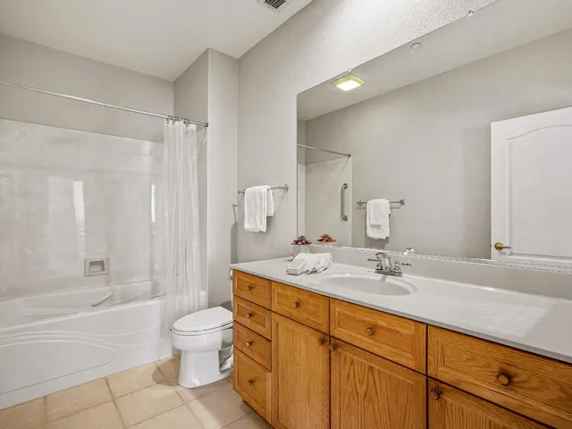 a bathroom with a double vanity sink toilet mirror and bathtub